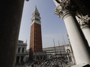 FILE - In this Wednesday, Oct. 4, 2017.  filer, tourists walk in St Mark's square in Venice, Italy, The mayor of Venice says Italy's new budget law includes a measure allowing the lagoon city to charge all visitors for accessing the historic center -- not just those sleeping in hotels or other accommodations. Mayor Luigi Brugnaro announced on Twitter late Sunday, Dec. 30, 2018 that the tax will ''allow us to manage the city better and to keep it clean,'' and ''above all allow Venetians to live with more decorum.'' The city council will determine the amount of the tax and collection mode.