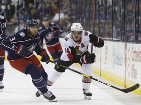 Senators Mark Borowiecki, right, dumps the puck past Blue Jackets defenceman Seth Jones during the first period of Monday's game.