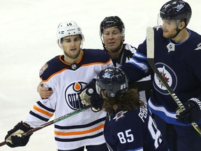 Defenceman Chris Wideman, left, exchanges verbal jabs with the Jets' Mathieu Perreault (85) during an Oilers game earlier this month. Wideman, who played only a handful of games for Edmonton after being acquired from the Ottawa Senators, was traded to the Panthers on Sunday.