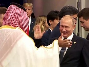 TOPSHOT - In this still image obtained from an Argentina G20 video, Russia's President Vladimir Putin (C) and Saudi Arabia's Crown Prince Mohammed bin Salman greet each other at the G20 Leaders' Summit in Buenos Aires, on November 30, 2018,