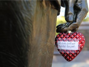 A heart ornament placed in tribute to former US President George H. W. Bush hangs off a hand at the President George H.W. Bush monument in Houston, Texas on December 1, 2018. Flags flew at half-staff in Washington as Americans prepared for a week of solemn tributes.