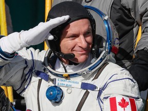 David Saint-Jacques of the Canadian Space Agency gestures as he boards the Soyuz MS-11 spacecraft shortly before the launch at the Russian-leased Baikonur cosmodrome in Kazakhstan on December 3, 2018.