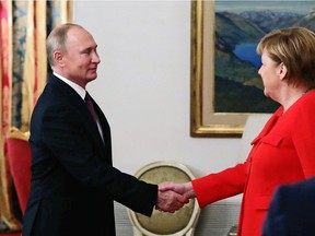 Russian President Vladimir Putin, left, greets German Chancellor Angela Merkel during their meeting at the G20 summit in Buenos Aires, Argentina, Saturday, Dec. 1, 2018.