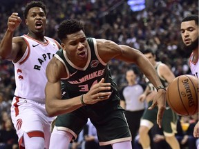 Milwaukee Bucks forward Giannis Antetokounmpo (34) chases a loose ball as Toronto Raptors guard Kyle Lowry (7) and Toronto Raptors guard Fred VanVleet (23) look on during first half NBA basketball action in Toronto on Sunday, Dec. 9, 2018.