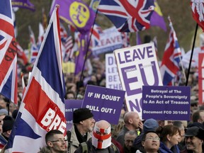 Demonstrators hold placards and flags at the "Brexit Betrayal Rally," a pro-Brexit rally, at Hyde Park Corner in London, Sunday Dec. 9, 2018.