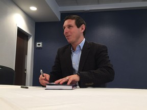 Former Ontario Progressive Conservative leader Patrick Brown signs a copy of his book in Ottawa on Saturday, Dec 15, 2017.