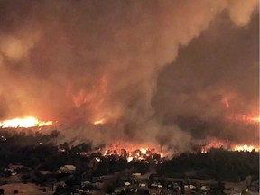 This July 26, 2018 file image taken from video released by Cal Fire shows a fire tornado over Lake Keswick Estates near Redding, Calif. A new study says a rare fire tornado that raged during the deadly wildfire this summer in Northern California was created by a combination of scorching weather, erratic winds and an ice-topped cloud that towered miles into the atmosphere. The study announce Wednesday, Dec. 5, 2018, in the Geophysical Research Letters journal used satellite and radar data to suggest how a monstrous "firenado" the size of three football fields developed on July 26.