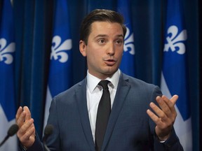 Coalition Avenir Quebec MNA Simon Jolin-Barrette responds to reporters questions on Tuesday, October 9, 2018 at the legislature in Quebec City. The new Coalition Avenir Quebec government says it will cut immigration to the province by roughly 20 cent next year.