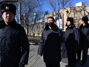Chinese police patrol in front of the Canadian embassy in Beijing Thursday. Security has been stepped up outside the embassy since Meng Wanzhou, the chief financial officer of Chinese telecom giant Huawei, was arrested in Canada, at Washington's request.