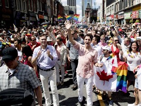 Prime Minister Justin Trudeau, centre, and Finance Minister Bill Morneau, left, take part in the annual Pride Parade in Toronto in 2016.