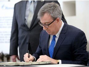 Mayor Jim Watson signs a Book of Condolences in memory of the victims of Friday's Westboro bus crash.