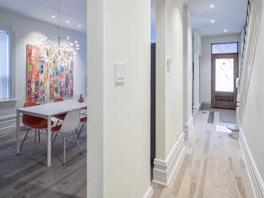 The dividing wall separating the hallway and the living and dining area was swapped for three vertical walls with cutouts between to offer glimpses into the trendy common areas.