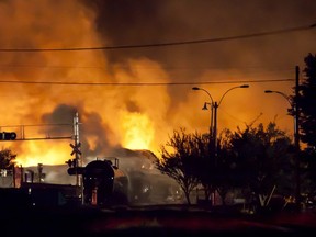 (FILES) This file photo taken on July 5, 2013 shows firefighters as they douse blazes after a freight train loaded with oil derailed in Lac-Megantic in Canada's Quebec province, sparking explosions that engulfed about 30 buildings in fire.