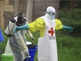 In this Sunday, Sept 9, 2018 file photo, a health worker sprays disinfectant on his colleague after working at an Ebola treatment centre in Beni, Eastern Congo.