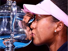 Naomi Osaka kisses the Daphne Akhurst Memorial Cup after defeating Petra Kvitova in three sets in the women's singles final of the Australian Open in Melbourne on Saturday. It was Osaka's second consecutive Grand Slam title.