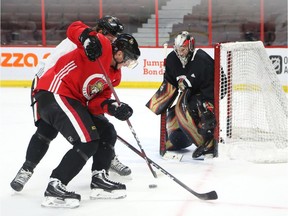 Matt Duchene, front, battles with Thomas Chabot in front of the net guarded by Craig Anderson during Senators practice on Tuesday