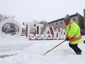 Jeremy Allan and Tammy Pigeon remove the snow in the ByWard Market in Ottawa during Wednesday's snowstorm.