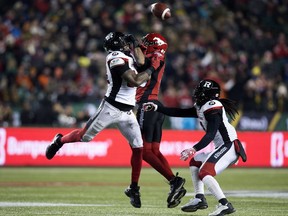 Redblacks linebacker Kyries Hebert, left, and Stampeders receiver Eric Rogers battle for a tipped football during the Grey Cup game at Edmonton on Nov. 25