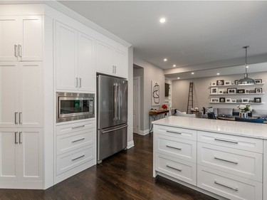 The previous angled lower cabinet was changed to a full-height pantry and kitchen wall to keep viable storage space and define the formal dining area.