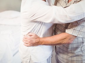 A man embracing a woman in a bedroom.