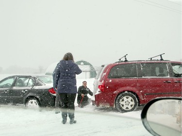 A man prepares to pull a car out of a ditch with his van on Bankfield Road Wednesday.