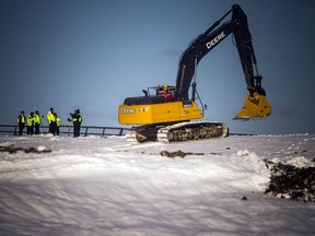 Ottawa police investigators stand by while heavy equipment continues working at the Trail Road landfill on Saturday during the search for the body of suspected homicide victim Susan Kuplu.
