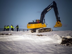 Ottawa police investigators stand by while heavy equipment continues working at the Trail Road landfill during the search for the body of suspected homicide victim Susan Kuplu.