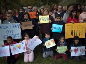 People hold messages of support as rescue workers continue efforts to find a boy who fell down a well in Totalan in southern Spain on January 16, 2019. - Rescuers racing to save a two-year-old boy who fell down a well in southern Spain have found several strands of his hair, authorities said, raising hopes of finding the toddler whose fate has gripped the nation for days. It is the first confirmation that Julen is down the 110-metre (360-foot) deep shaft after family members said he tumbled in while playing as his parents had lunch nearby.