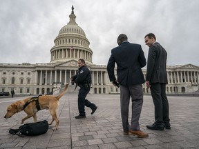 A police officer and K-9 do a routine security check at the Capitol as the partial government shutdown lurches into a third week with President Donald Trump standing firm in his border wall funding demands, in Washington, Monday, Jan. 7, 2019. After no weekend breakthrough to end a prolonged shutdown, newly empowered House Democrats are planning to step up pressure on Trump and Republican lawmakers to reopen the government.