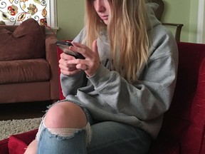 In this Nov. 1, 2018 photo, Laurel Foster holds her phone in San Francisco. Foster is among teens involved in Stanford University research testing whether smartphones can be used to help detect depression and potential self-harm.
