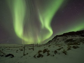 FILE - In this March 1, 2017 file photo, the Northern Lights, or aurora borealis, appear in the sky over Bifrost, Western Iceland. Police in Iceland say tourists are often putting themselves at risk searching for the Northern Lights, whose spectacular streaks of color light up the winter skies at night. Police say sleep-deprived tourists are dividing their attentions between the road and the sky, and often underestimate the challenging conditions posed by Iceland's twisty, narrow, often-icy roads in the winter.