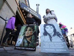 FILE- In this Jan. 25, 2019, file photo Brenda Jenkyns, left, and Catherine Van Tighem who drove from Calgary, Canada stand with signs outside of the premiere of the "Leaving Neverland" Michael Jackson documentary film at the Egyptian Theatre on Main Street during the 2019 Sundance Film Festival in Park City, Utah. Michael Jackson's family members said Monday, Jan. 28, that they are "furious" that two men who accuse him of sexually abusing them as boys have received renewed attention because of a new documentary about them. The family released a statement denouncing "Leaving Neverland," a documentary film featuring Jackson accusers Wade Robson and James Safechuck.
