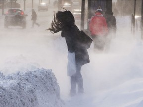 Pedestrians battle the blowing snow and wind chill.