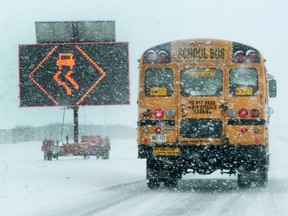 A school bus drives through the snow on Greenbank Road.