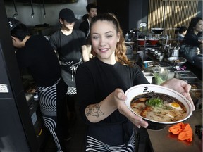 Server Marlie Dodds holding pork tonkotsu at Sansotei in Ottawa Friday Jan 18, 2019. Sansotei is one of dozens of restaurants offering takeout and delivery during the COVID-19 pandemic.