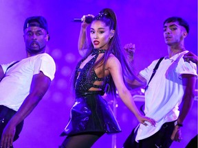 FILE - In this June 2, 2018 file photo, Ariana Grande, center, performs.