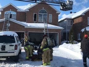 Ottawa firefighters gather their gear after a fire at a Barrhaven duplex Friday.