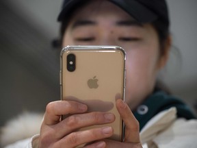 Files: A woman uses an Apple iPhone at a shopping mall in Beijing.