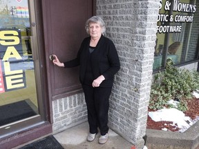 Elaine Ferguson stands outside her Golden Soles specialty shop where a large wooden railing was stolen this week.