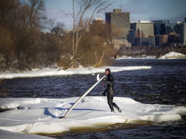 Tristan Lafontaine gets out of the Ottawa River after a surf session on Saturday.