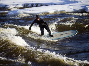 Tristan Lafontaine surfs on the Ottawa River on Saturday.