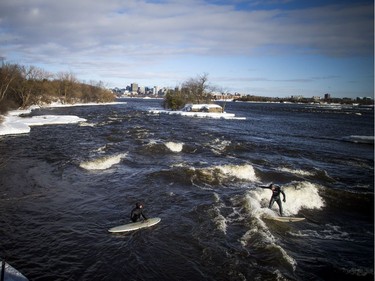 Pierre-Karl Sanscartier, right, surfs on the Ottawa River as Tristan Lafontaine watches on Saturday.