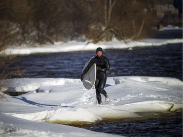 Tristan Lafontaine gets out of the Ottawa River after a surf session on Saturday.