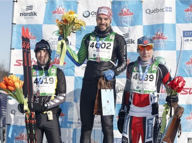 First place Luc Campbell, centre, second place Stephane Martel, left, and third place Dave McMahon, right, take part in the ceremony for the men's 27km free technique cross-country ski race at the Gatineau Loppet on Sunday, February 17, 2019.