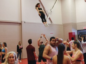 A woman heads downwards during a stunting tryout at Collège St-Jean-Vianney in the Rivière-des-Prairies–Pointe-aux-Trembles area of Montreal Saturday, February 23, 2019. The Montreal Alouettes held auditions for their cheerleading squad. The team invited men and women to try out to be stunters and dancers.