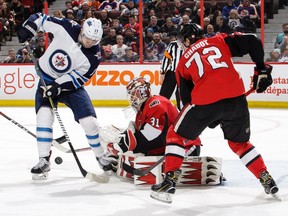 Anders Nilsson #31 of the Ottawa Senators makes a save against Adam Lowry #17 of the Winnipeg Jets as Thomas Chabot #72 of the Ottawa Senators looks on in the third period at Canadian Tire Centre on February 9, 2019 in Ottawa, Ontario, Canada.