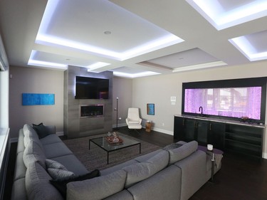 The great room in the two-storey home is defined by a 'bubble wall' water feature and a chunky coffered ceiling inset with LED accent lighting.