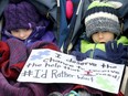Amara LeBlanc, 4, and her friend Kevin Maillot, 4, sit in a stroller while their parents protest outside the Barrhaven constituency office of Social Services minister Lisa MacLeod on Friday.