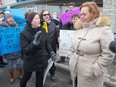 Parents take their protest against changes to the Ontario Autism Program to MPP Lisa MacLeod outside her constituency office in Barrhaven on Friday.