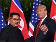This file photo taken on June 12, 2018 shows U.S. President Donald Trump (R) gesturing as he meets with North Korea's leader Kim Jong-Un (L) at the start of their historic US-North Korea summit, at the Capella Hotel on Sentosa island in Singapore. They'll meet again this week in Hanoi.